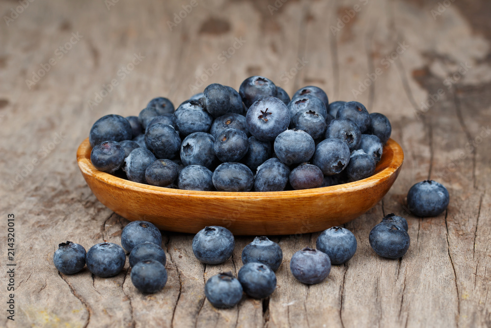 Blueberries in a wood bowl on a wooden table, Healthy eating and nutrition concept Blueberries in a wood bowl on a wooden table, Healthy eating and nutrition concept