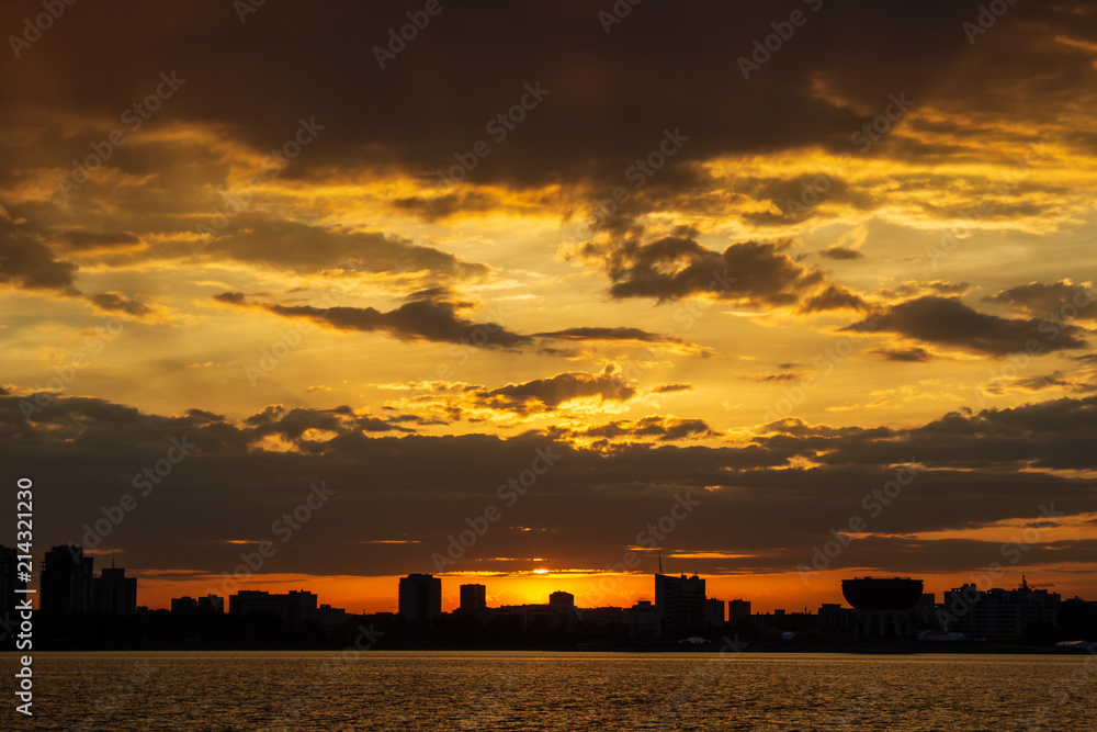 sunset over the waterfront with silhouettes of buildings