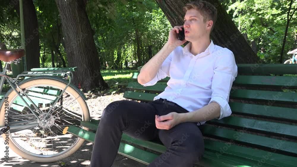 Lovely young Caucasian student business man cellphone conversation sitting bench Lovely young Caucasian student business man cellphone conversation sitting bench