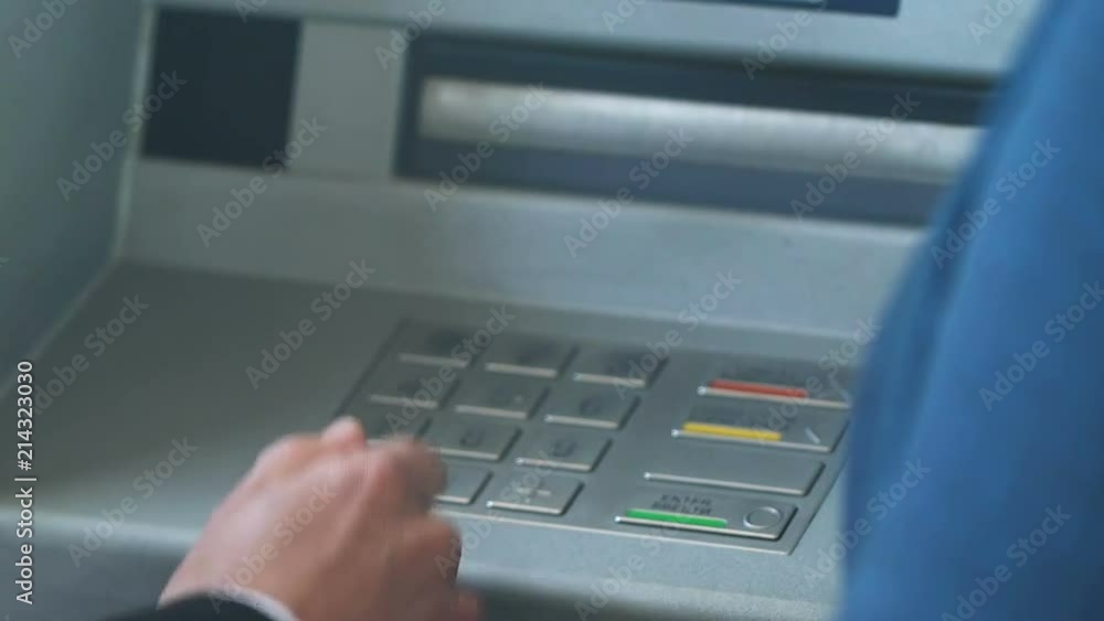 Female bank worker showing new male client how to work with ATM, service Female bank worker showing new male client how to work with ATM, service
