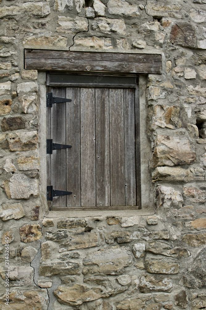 Wood plank window on a very old round stone tower grist mill (windmill)