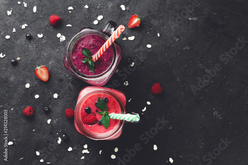 Fresh, cold smoothies from raspberries and blueberries with berries on a dark background. Healthy diet. Summer