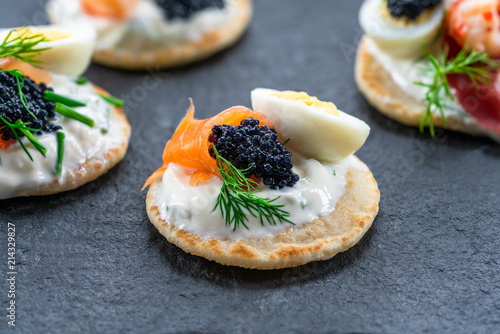 Tableau sur toile Selection of cocktail blinis with salmon, cured bresaola, crayfish, caviar, quai