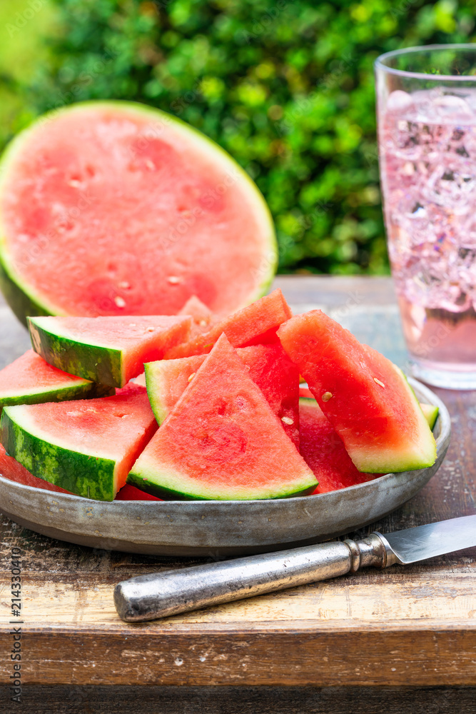 Slices of sweet, refreshing watermelon on a garden table. Summer outdoor eating. Slices of sweet, refreshing watermelon on a garden table. Summer outdoor eating.