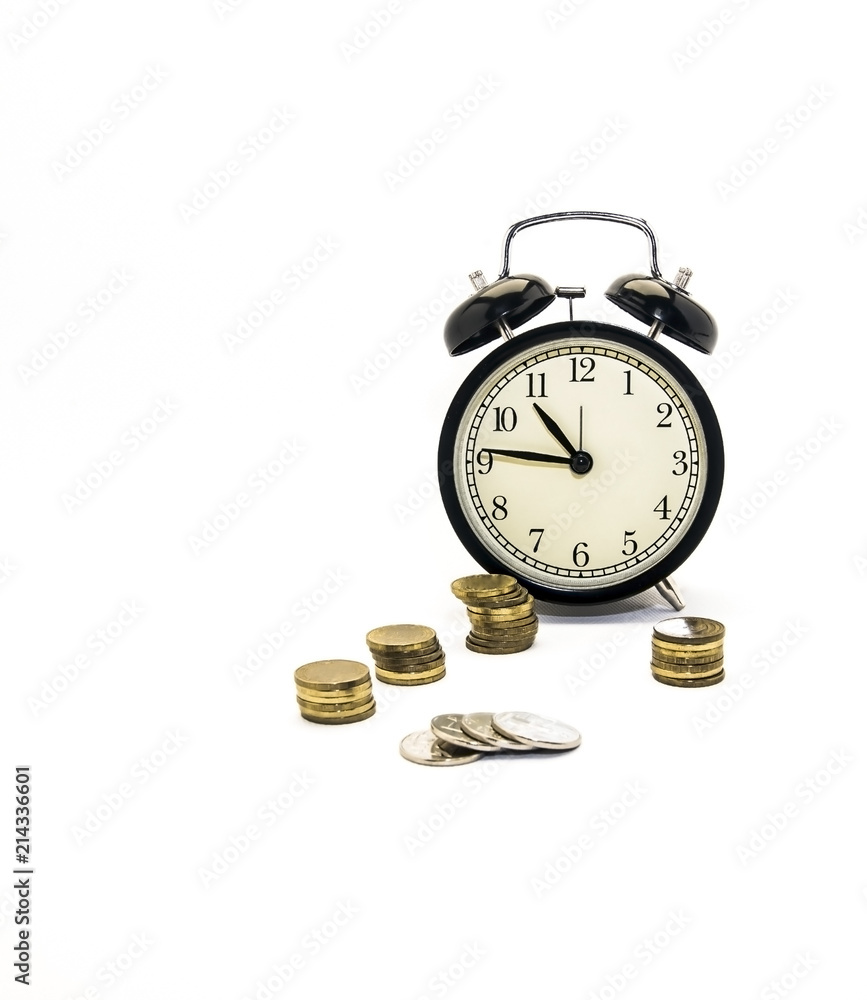 Folded coins next to a retro-alarm clock on a white background, the concept of saving time and money in the future.