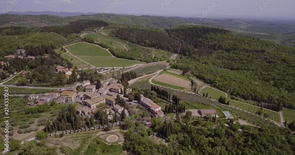 Aerial, a little village in Tuscany, Italy, in the middle of olive trees and vineyards on a sunny day Aerial, a little village in Tuscany, Italy, in the middle of olive trees and vineyards on a sunny day