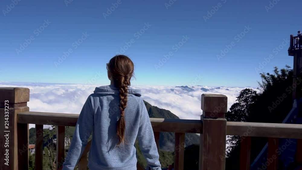 Travel concept. Woman raising hands on Fansipan mountain in Sapa, Vietnam Travel concept. Woman raising hands on Fansipan mountain in Sapa, Vietnam