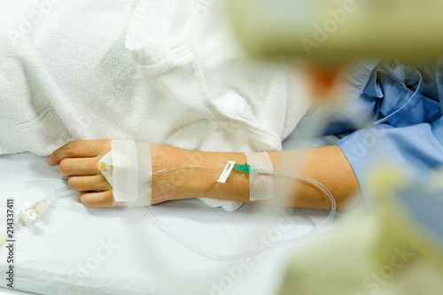 Close up image of IV drip in patient s hand in hospital.