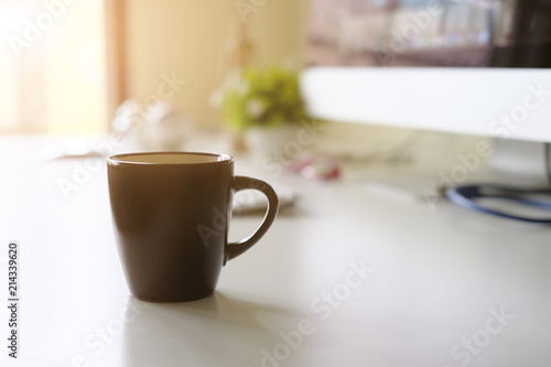 Mug of coffee on office workplace with morning coffee concept.