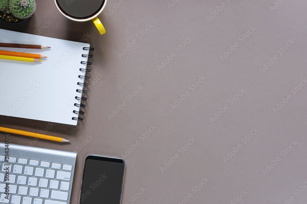Office desk coffee cup and pencil with notepad paper on brown table background, Top view workspace. Office desk coffee cup and pencil with notepad paper on brown table background, Top view workspace.