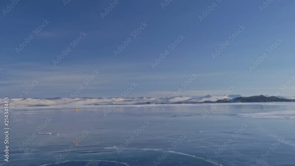 Toy Terrier in funny clothes and funny shoes plays with ball on beautiful ice in cracks. Mom and daughter in sports clothes and figure skates. Girls throw toy to dog. Doggy catches up favorite toy