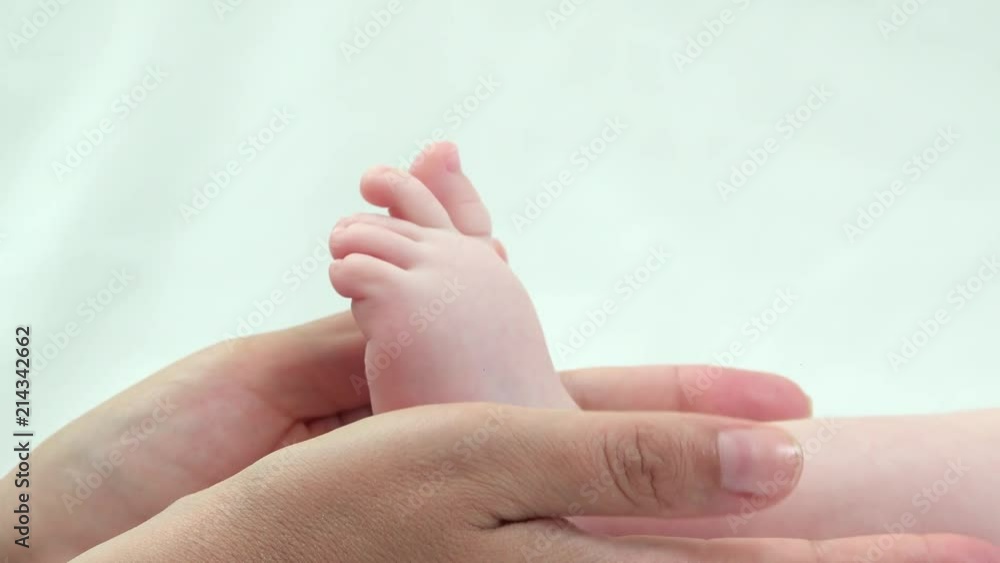 Detail of mother hands holding baby sole, delicate touch of little foot