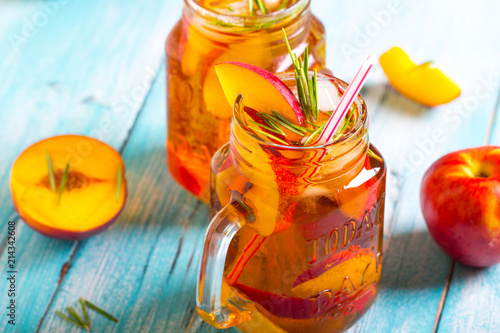 peach ice tea  fresh mint rosemary wooden background