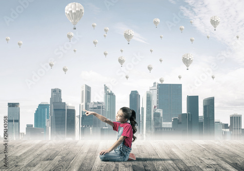 Cuadro en lienzo Concept of careless happy childhood with girl pointing at someth