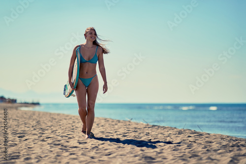 Sexy surfer girl walking with board on the sandy beach. Healthy Active Lifestyle. Surfing. Summer Vacation. .