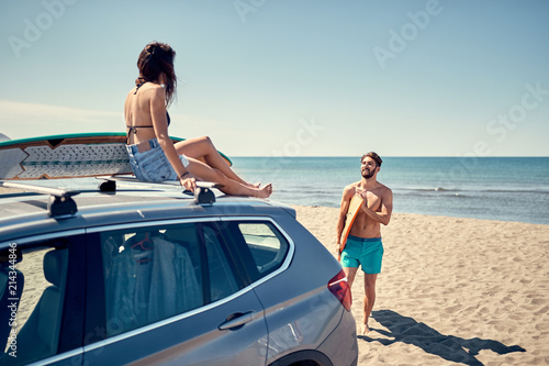 Healthy Active Lifestyle. Surfing. Summer Vacation. Extreme Sport. surfer girl sitting on the car and getting ready for surfing. © luckybusiness