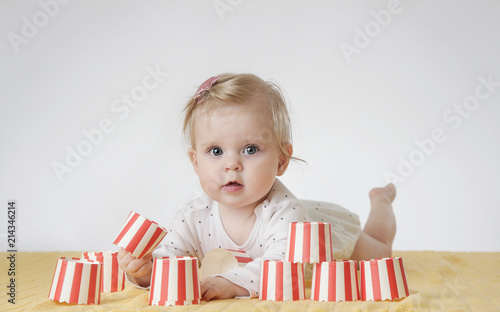 Cute baby girl playing with paper cups
