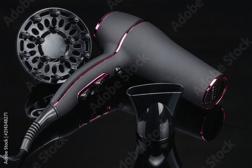 Grey mat hair dryer on the black mirror background with accessory