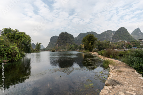 Panoramic view of green mountains reflected in still water. Yangshou  China