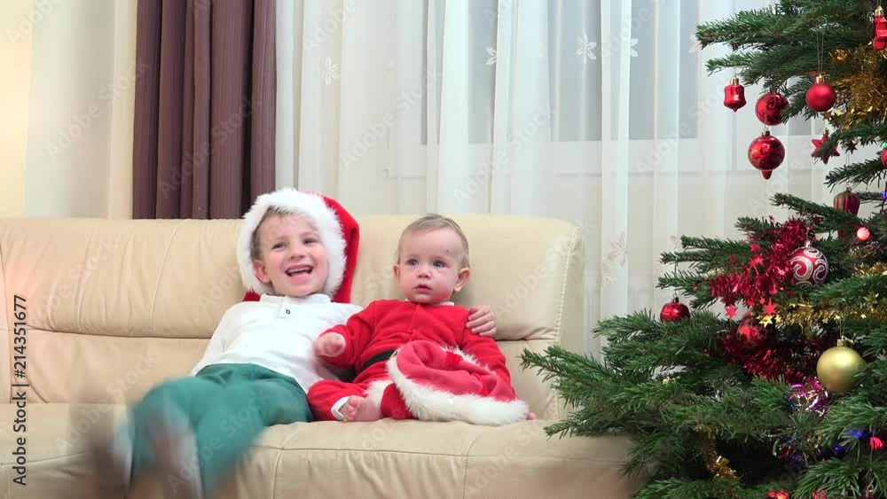 Happy brothers embrace smiling laughing close Christmas tree, Santa costume, fell the real joy of celebration close family Happy brothers embrace smiling laughing close Christmas tree, Santa costume, fell the real joy of celebration close family