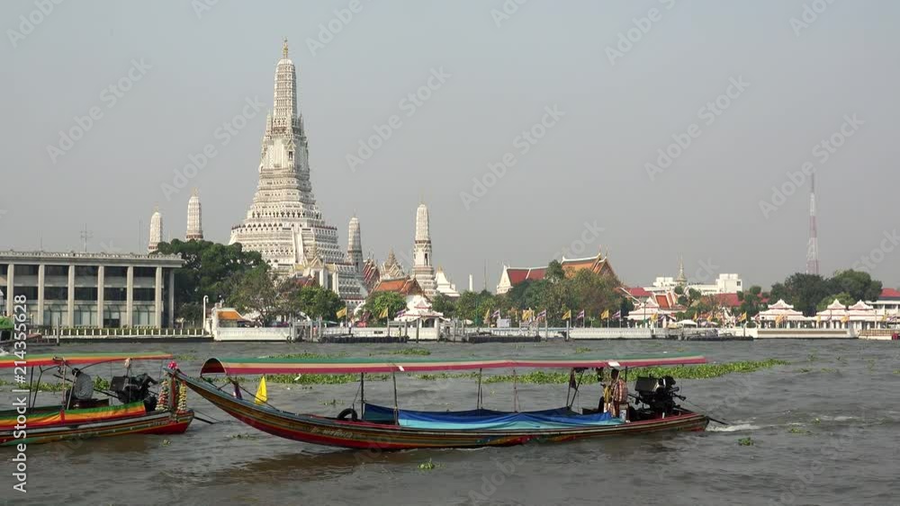 Long boats on Chao Phraya river in front of Wat Arun Temple, Bangkok, Thailand Long boats on Chao Phraya river in front of Wat Arun Temple, Bangkok, Thailand