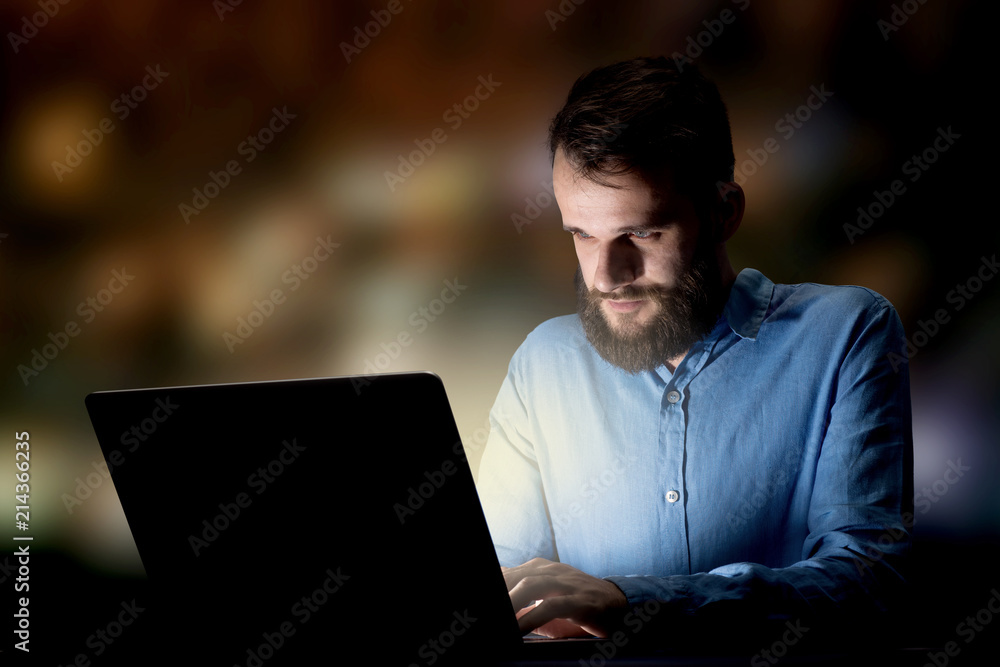Young handsome businessman working late at night in the office Young handsome businessman working late at night in the office