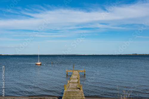 small sailboat in the water near the coast of Denmark photo