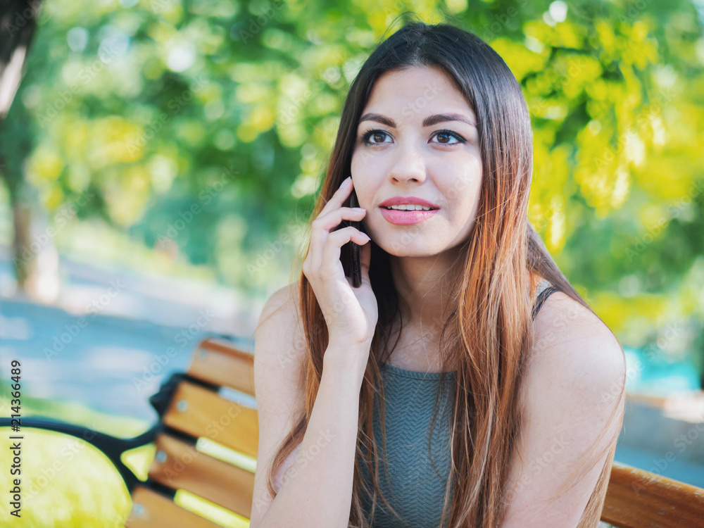 Female speaking on her cellphone. Technology, smartphone concept. Woman have conversation with friend. Talking and smiling girl with oriental face. Female speaking on her cellphone. Technology, smartphone concept. Woman have conversation with friend. Talking and smiling girl with oriental face.