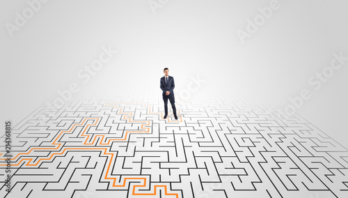 Young entrepreneur standing in a middle of a labyrinth with the solution 