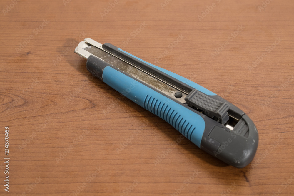 Blue cutter blade on a wood table Blue cutter blade on a wood table