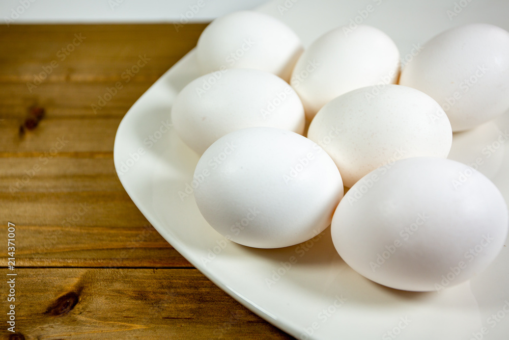 Eggs on a while plate sitting on the kitchen table waiting to be cracked Eggs on a while plate sitting on the kitchen table waiting to be cracked
