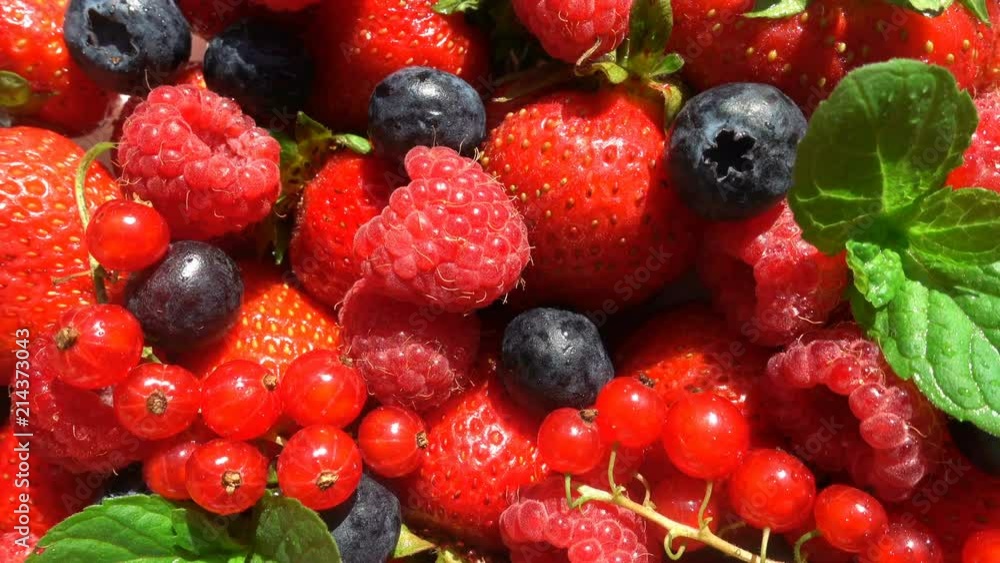 Red ripe garden strawberry and blueberry, rotation of berries on white table, beautiful background Red ripe garden strawberry and blueberry, rotation of berries on white table, beautiful background