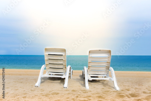 Sand beach with coconut trees with two chairs and bokeh beach tropical background, summer vacation and travel ideas, relaxation © Surasak