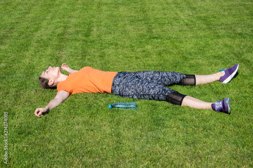 Delighted girl sitting in the park after workout