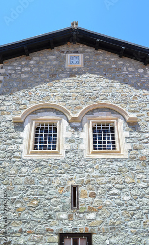 Window on a stone wall of the house. Due to the windows location, facade looks like a human face photo