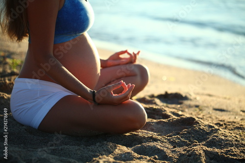 pregnant girl doing yoga sand beach sea