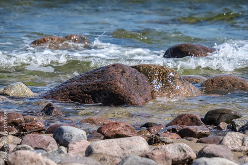 rocky sea beach with waves and sunny day