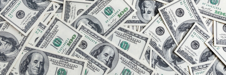 A pile of one hundred US banknotes. Cash of hundred dollar bills, dollar background image.