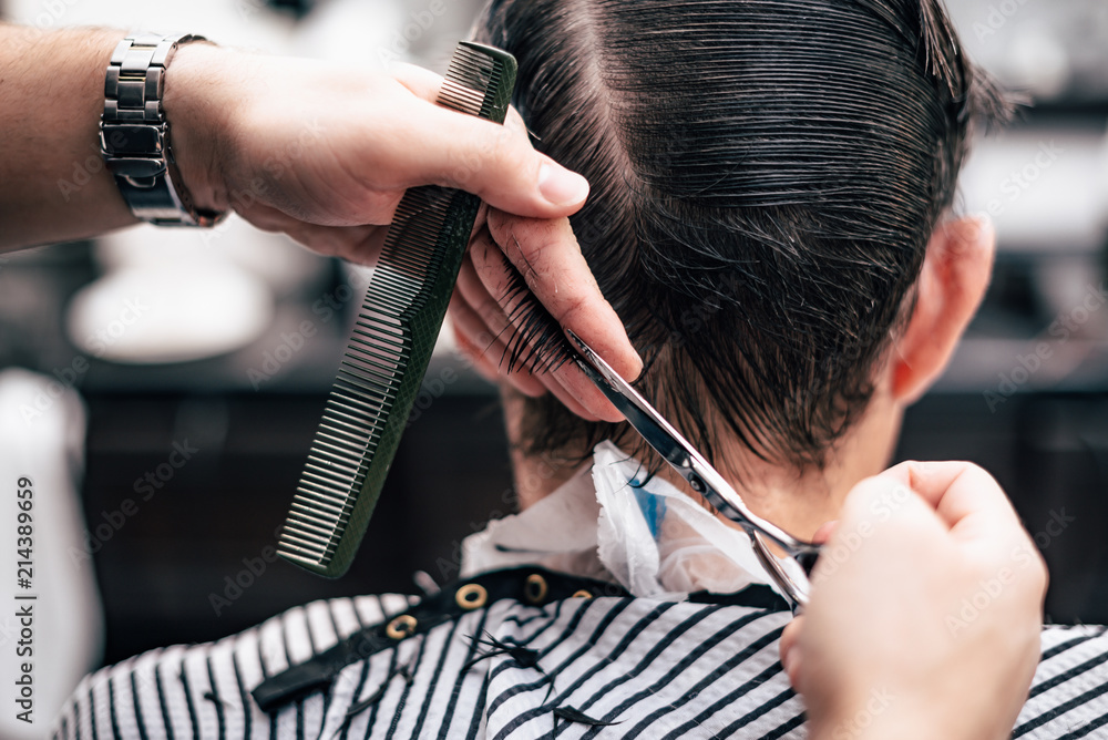 Barber in shear hair electric car to young guy hipper for