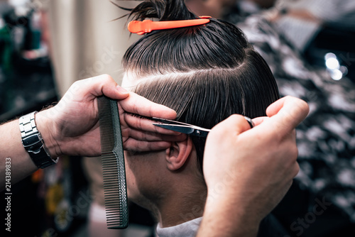 A man is hanging around in a beauty salon. Haircut and styling in barbershop. Men's care for beard and hair.