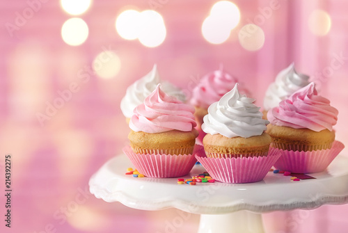 фотография Dessert stand with delicious cupcakes on blurred background