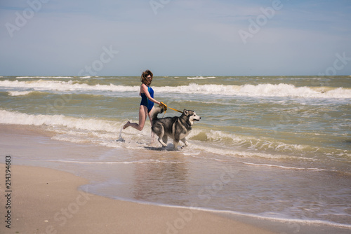 Woman run with dog at seaside