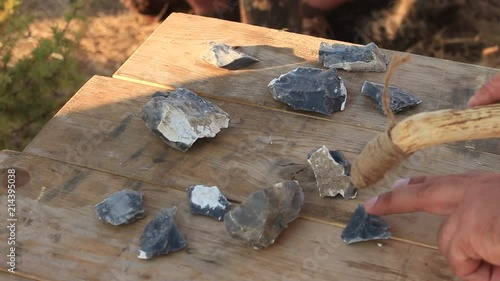 Prehistoric Man is Using Iron Tool for Sharpening Stones photo
