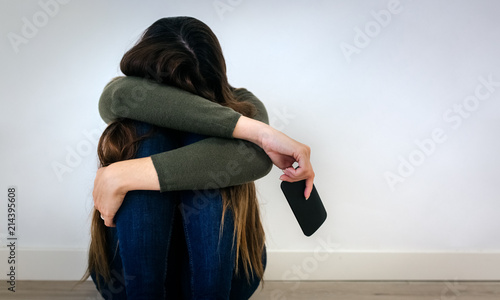 Devastated young woman holding a phone photo