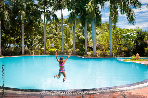 Child with goggles in swimming pool. Kids swim.