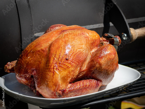 Принти на полотні Smoked turkey on a white plate in front of a black smoker