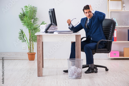 Young handsome businessman employee working in office in paperwo photo