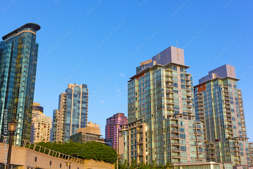 City skyline in Coal Harbor waterfront neighborhood in Vancouver BC, Canada. Vancouver city skyscrapers at sunrise in summer.