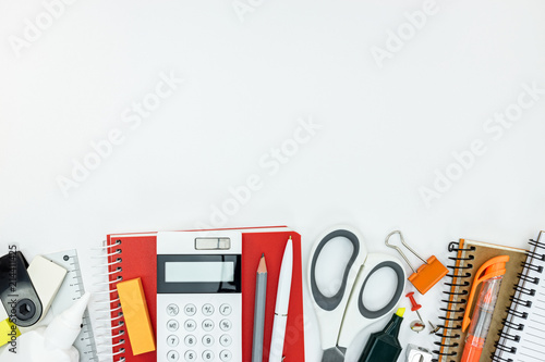 office supplies with notebook, pencils, pens, markers on white table background