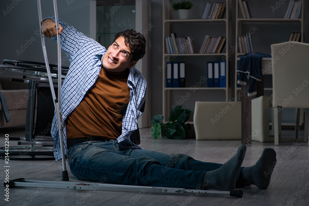 Fototapeta premium Man fell off wheelchair sitting on the floor